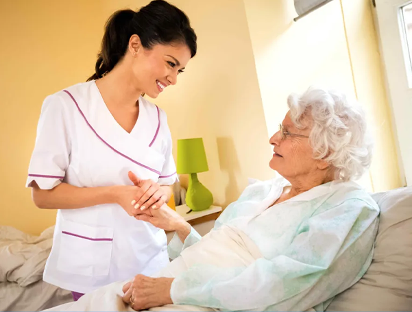 Caring nurse holding the hand of an elderly patient in bed, symbolizing comprehensive ventilator care seattle support