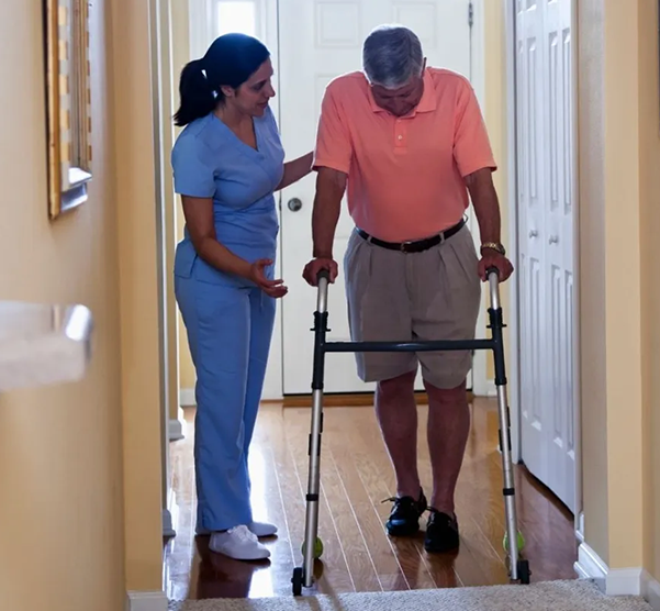 Home health aide assisting senior man with physical therapy, related to ventilator care seattle recovery.